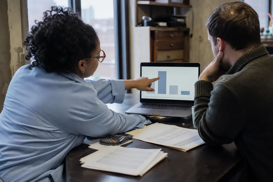 Finance analyst and data lead reviewing a prepaid software credit balance on a laptop
